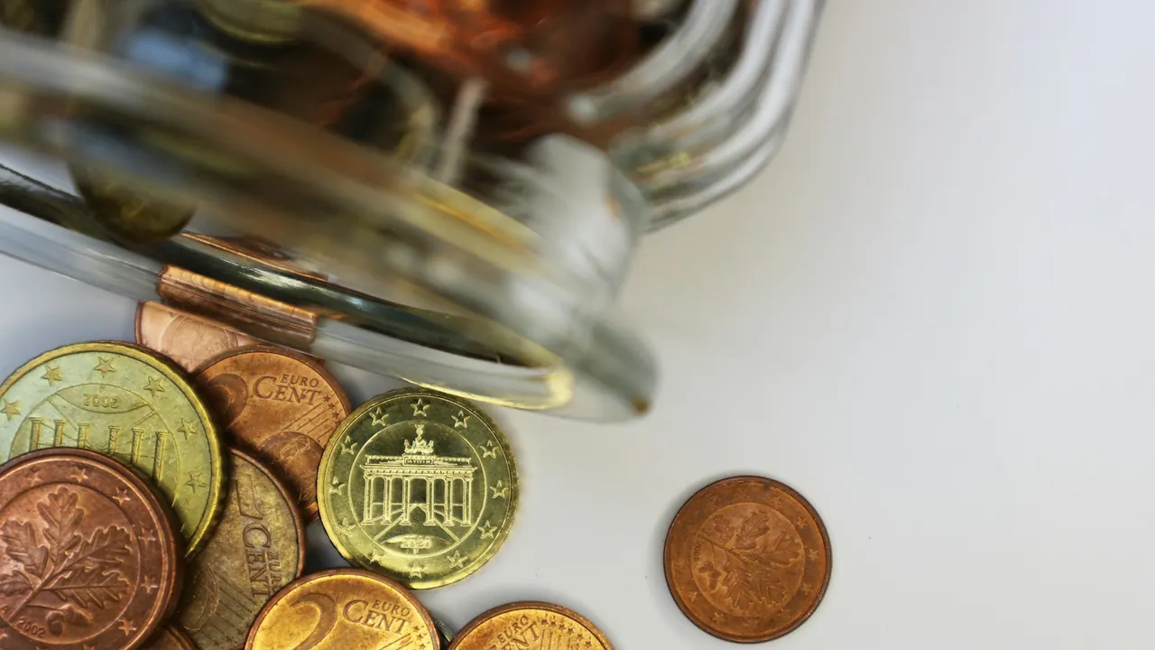 Euro coins spilling from a jar