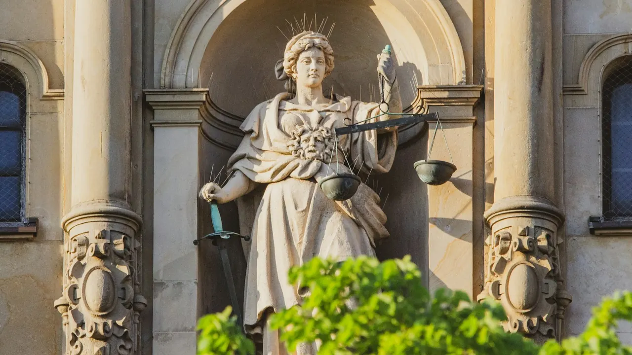 Statue of Justice on a historic façade